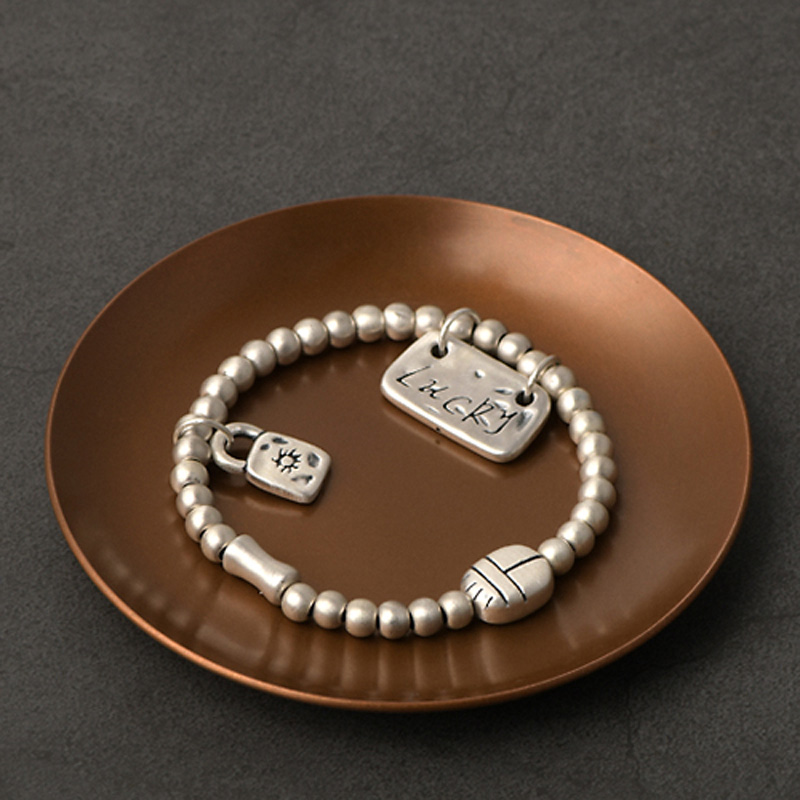 Silver bead bracelet photographed to compare fineness, bead shape and construction